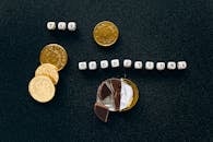 Creative concept of tax deductions using chocolate coins and letter tiles on a black background.