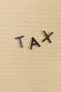 Conceptual still life image with the word 'Tax' on lined paper, perfect for financial themes.
